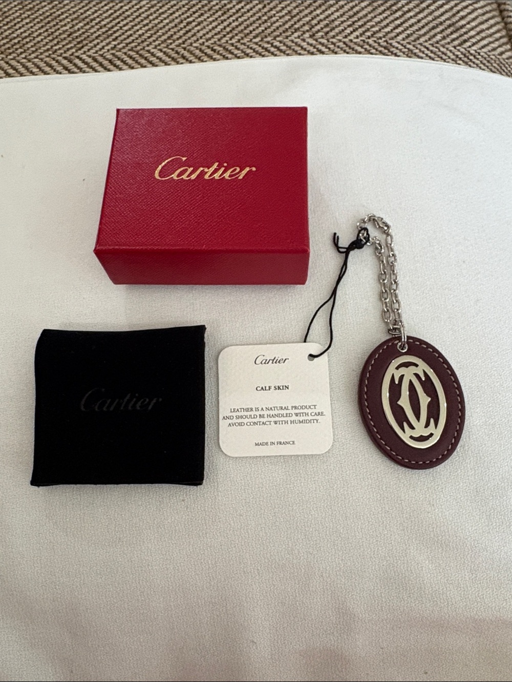 NEW Cartier oval calf skin key chain with silver tone Cartier Emblem.